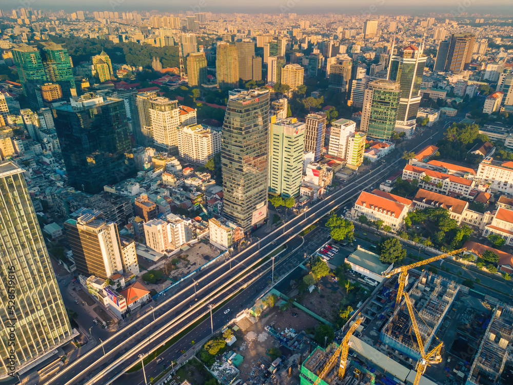 Fototapeta premium Aerial panoramic cityscape view of Ho Chi Minh city and Saigon river, Vietnam. Center of heart business at downtown with buildings and towers.