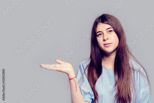 Girl with thick eyebrows and long dark hair holding her palm