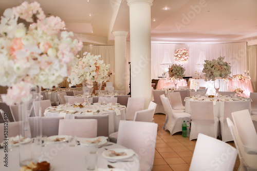 festive wedding table decoration with crystal chandeliers, golden candlesticks, candles and white pink flowers . stylish wedding day