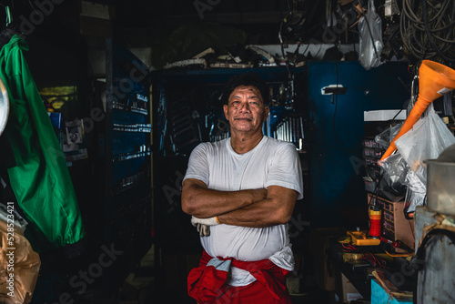 Arms crossed of auto mechanic in the garage.