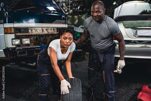 Mechanic female amd male wearing gloves checking wheels and tires.