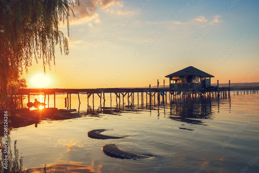 Sunset over the sea lake and old wooden pier, romantic travel destination, nature landscape