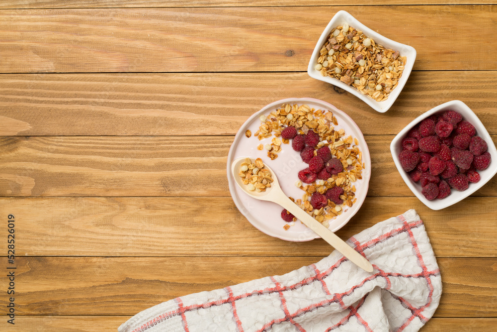 Bowl with granola, yogurt and fresh berries on wooden background, top view Bowl with granola, yogurt and fresh berries on wooden background, top view