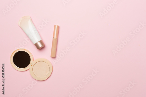 Makeup products for skin tone on color background, top view