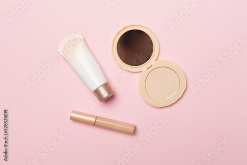 Makeup products for skin tone on color background, top view