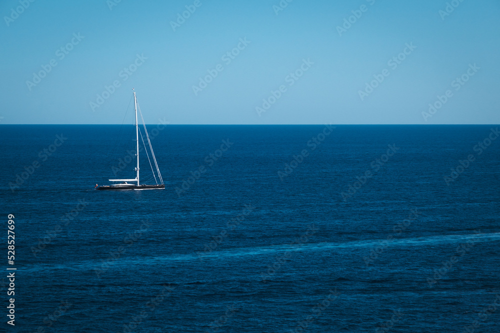Yacht in the blue sea background, small sailboat adventure, seascape, boat travel through on the deep ocean horizon.