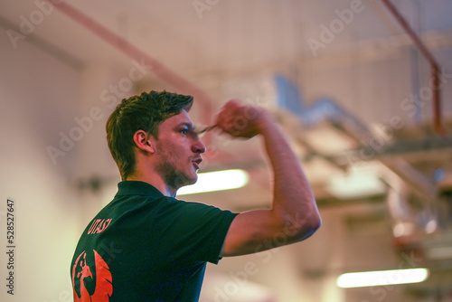 Aiming with the arrow at a darts competition photo