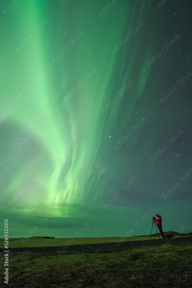 Traveler taking photo of northern lights at night Traveler taking photo of northern lights at night
