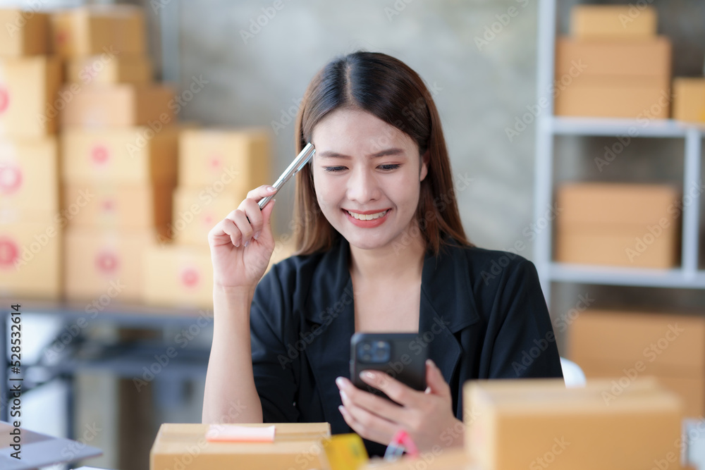 Online business owner Asian woman answer phone chat with customers and write down detail of customer who deliver negotiated address to verify correct detail. Online business owner Asian woman answer phone chat with customers and write down detail of customer who deliver negotiated address to verify correct detail.