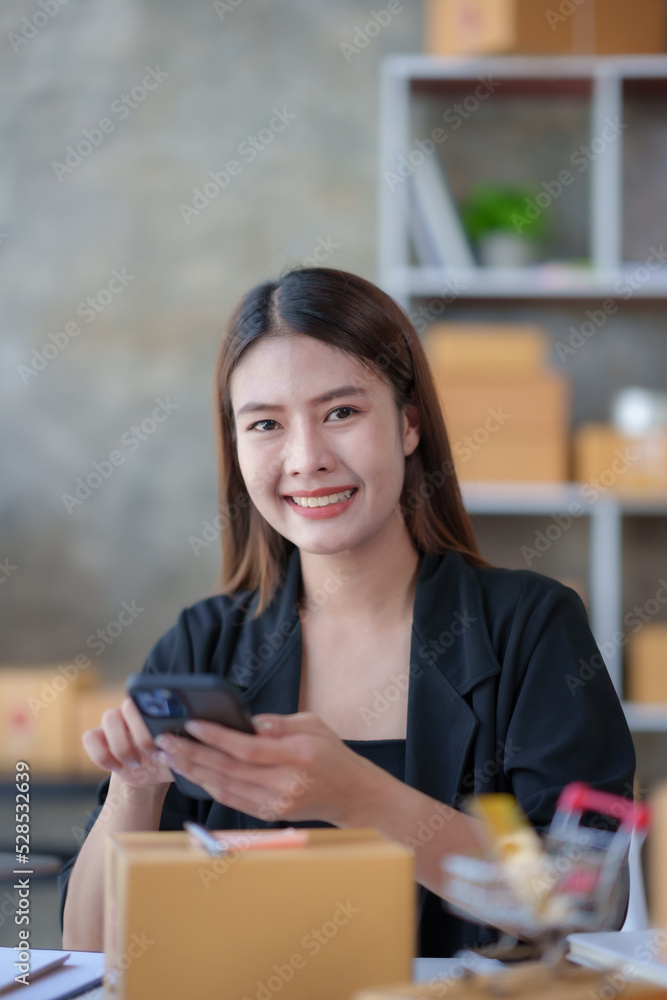 Fototapeta premium Online business owner Asian woman answer phone chat with customers and write down detail of customer who deliver negotiated address to verify correct detail.