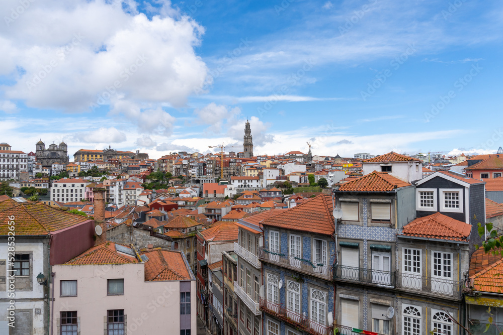 Panoramic view of Porto, seen from the cathedral, with the bell towers of the churches and the colored houses on a sunny day with clouds.