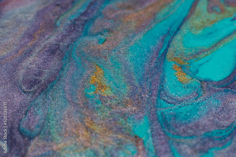 Mixing colors. Fluid magic. Creative painting. Cyan blue purple gold stream of liquid paint floating. Marble effect