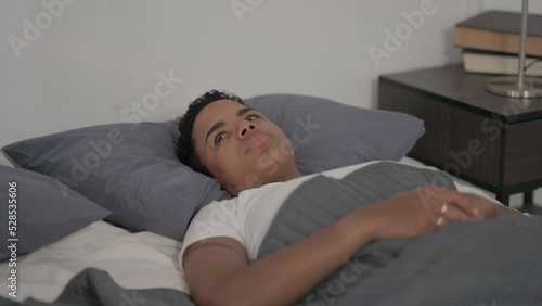 African Woman Awake in Bed Thinking