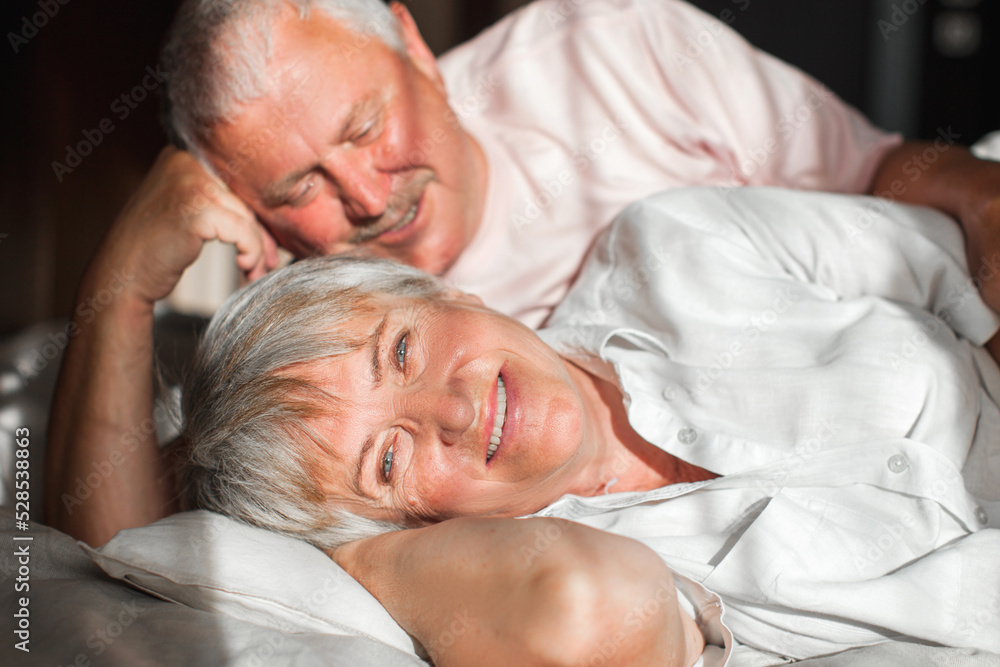 Happy elderly couple wakes up in bed in the morning Happy elderly couple wakes up in bed in the morning