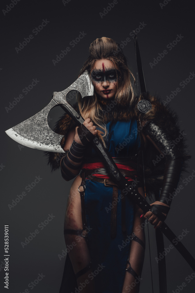 Shot of warrior woman with make up dressed in attire and fur looking at camera.