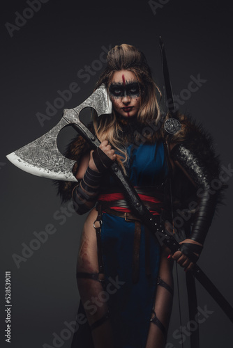Quadro su tela Shot of warrior woman with make up dressed in attire and fur looking at camera