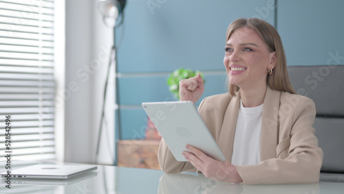 Businesswoman Celebrating Success on Tablet in Office