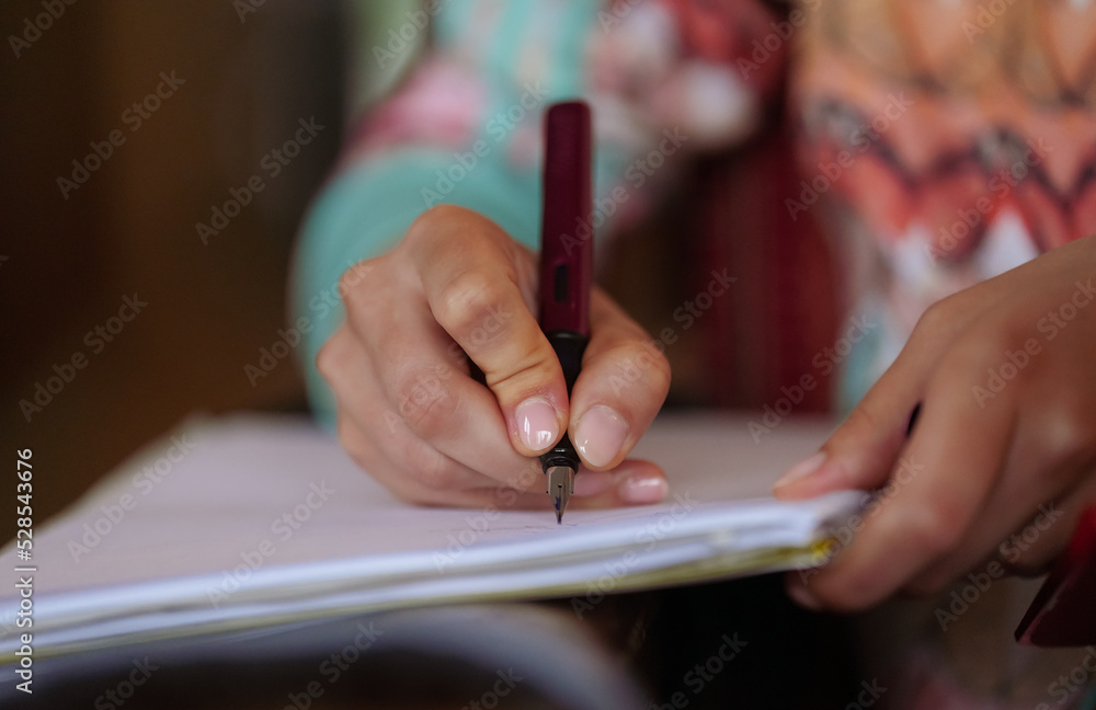 Detail view of a teacher's hand writing with a pen in a notebook. Concept photo for starting of the new school year. Detail view of a teacher's hand writing with a pen in a notebook. Concept photo for starting of the new school year.