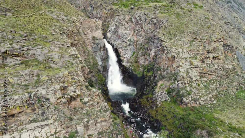Aerial view of waterfall in wild rocky environment. Altai region natural landmark. Aerial view of waterfall in wild rocky environment. Altai region natural landmark.