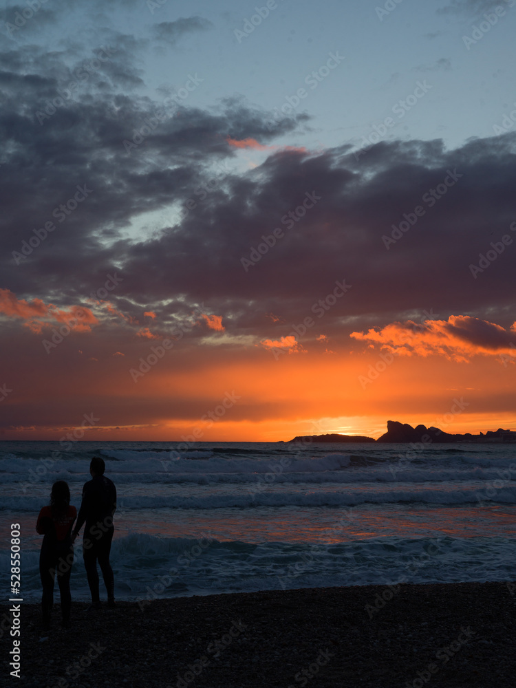 Fototapeta premium silhouette of a couple walking on the beach