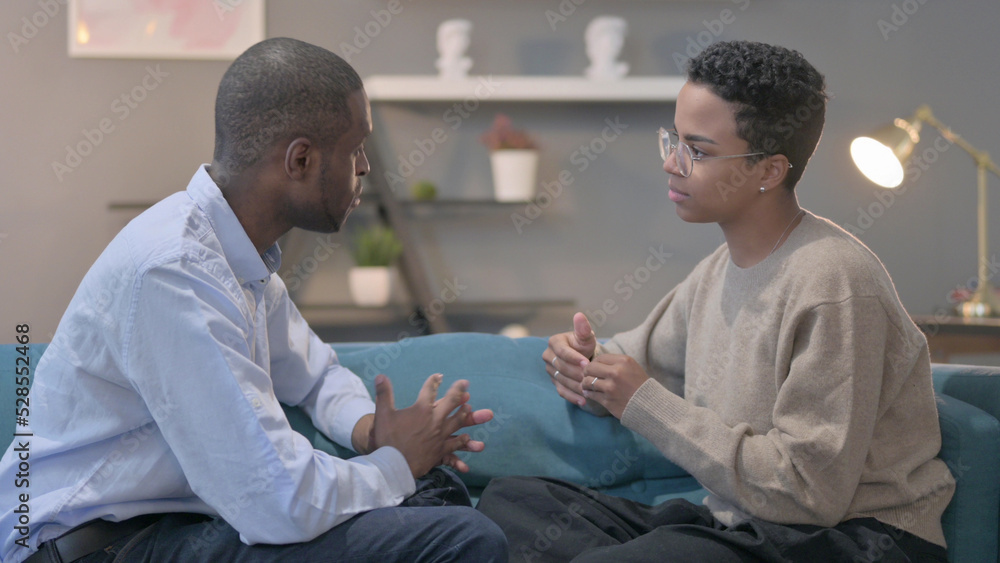 Angry African Man Talking to African Woman While Sitting on Sofa Angry African Man Talking to African Woman While Sitting on Sofa