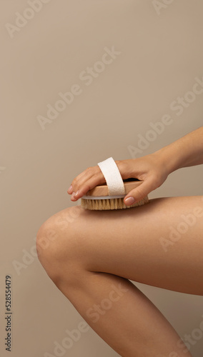 Womam using dry body brush to reduce cellulite, beauty concept. space for text