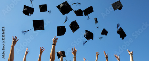 Graduation Caps Thrown in the Air on blue sky photo