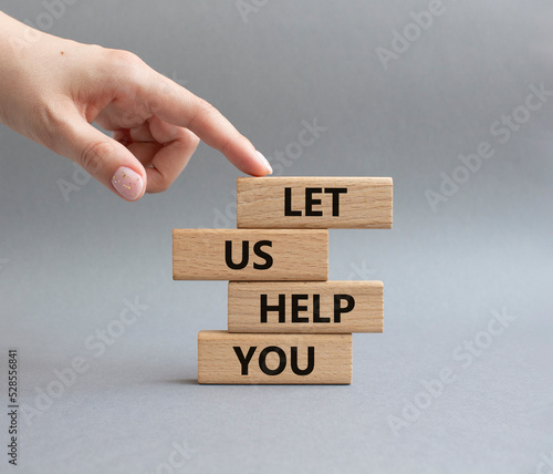 Let us help you symbol. Wooden blocks with words Let us help you. Beautiful grey background. Businessman hand. Business and Let us help you concept. Copy space.