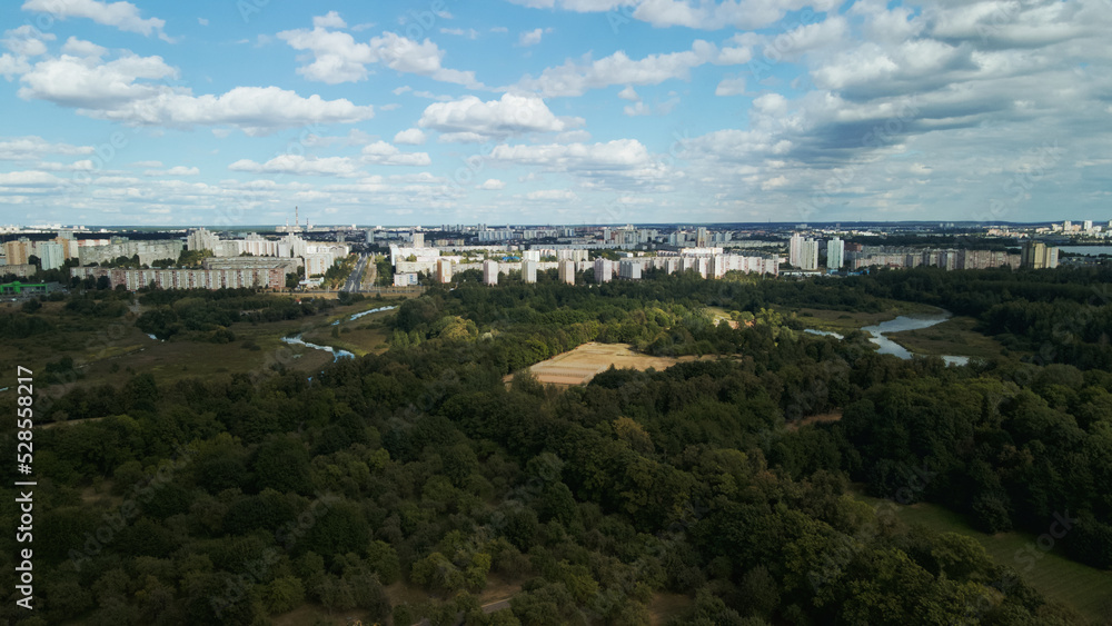 City with high-rise buildings. Park area in the foreground. Blue sky with clouds. Aerial photography.