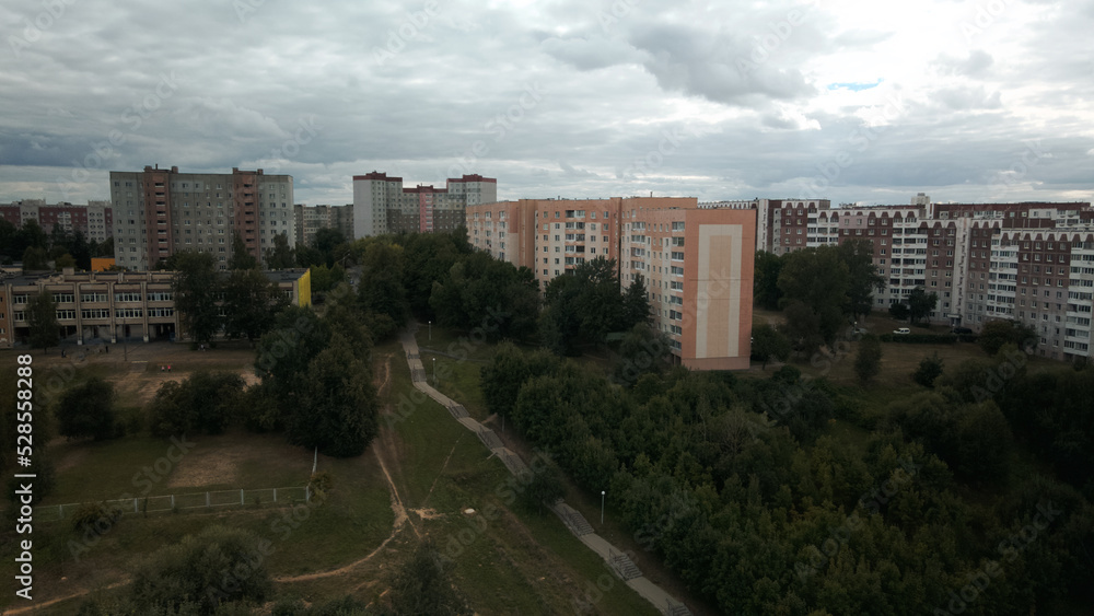 City with high-rise buildings. Park area in the foreground. Blue sky with clouds. Aerial photography.