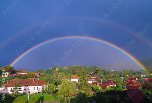landscape of a semicircle rainbow over the village © sebi_2569