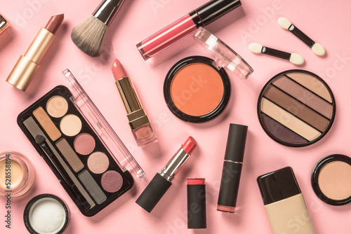 Make up products flat lay at pink background. Eye shadow, powder, cream, lipstick and more for professional make up.
