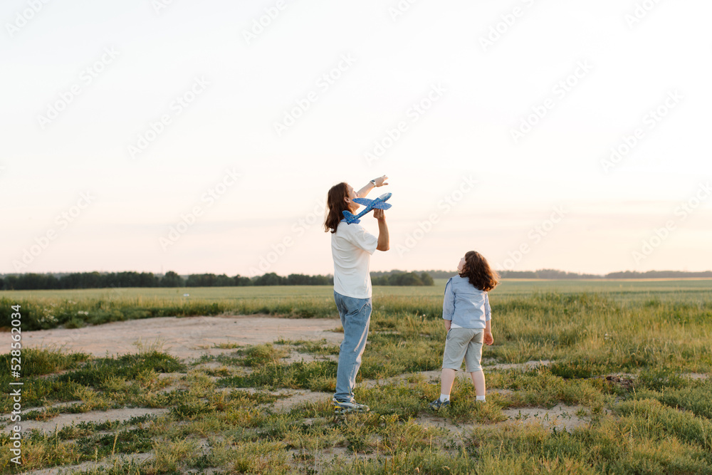 Boys, children run through wheat field play with toy airplane in hand, dream of flying. Child plays with his toy with an plane. Elder and younger brothers. High quality photo Boys, children run through wheat field play with toy airplane in hand, dream of flying. Child plays with his toy with an plane. Elder and younger brothers. High quality photo