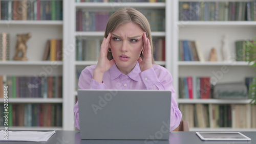 Woman having Headache while Working on Laptop