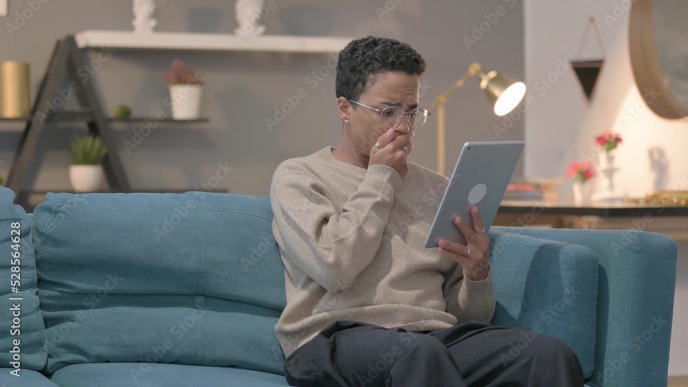 African Woman having Loss on Tablet on Sofa African Woman having Loss on Tablet on Sofa