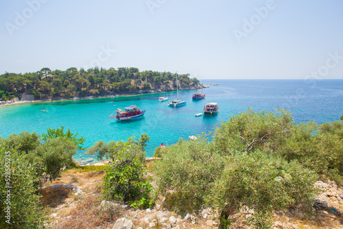 Tourist boats at picturesque bay with amazing crystal turquoise color of the sea. Serenity of the natural environment. Summer travel concept. 