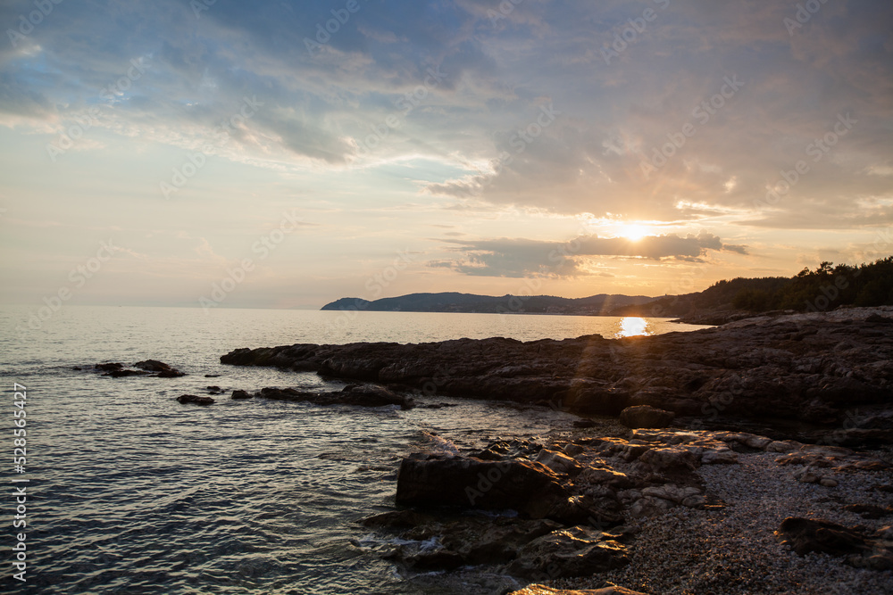 Romantic summer sunset or sunrise landscape over seascape horizon. Sunlight reflection on water surface. Golden hours lights at rocky beach.
Romantic summer sunset or sunrise landscape over seascape horizon. Sunlight reflection on water surface. Golden hours lights at rocky beach.
