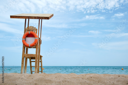 Emplty wooden lifeguard station on sandy beach on ocean shore in summer