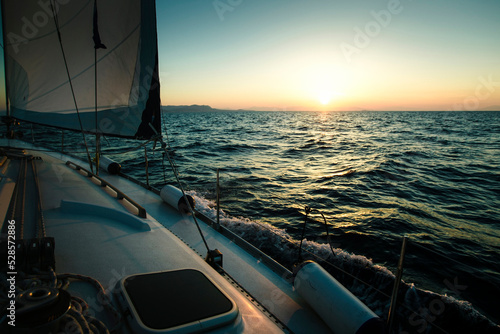 Sailing yacht boat in the Sea during amazing sunset.