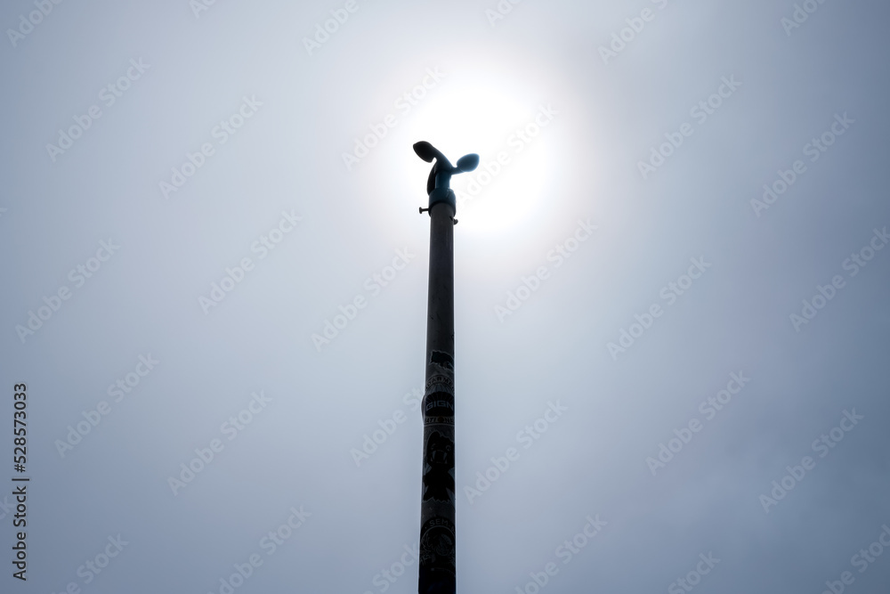 Backlit anemometer on a pole against the blue sky. Backlit anemometer on a pole against the blue sky.