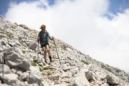 Woman Tourist Hiker Descending from the Summit of a High Mountain