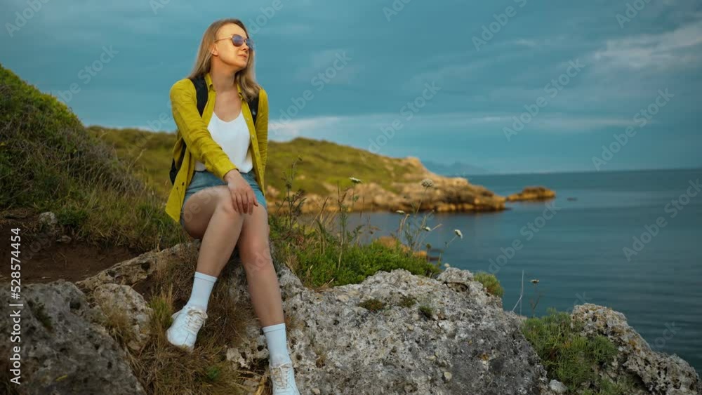 Woman tourist with backpack enjoying sunset in sea coast. Woman tourist with backpack enjoying sunset in sea coast.