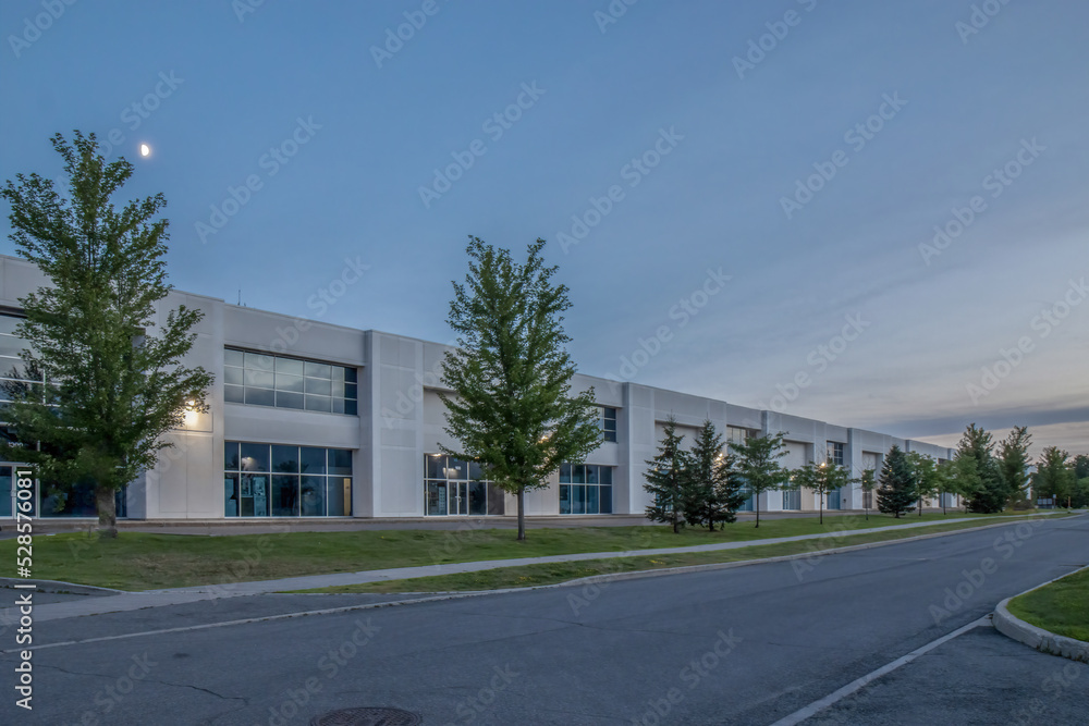 Exterior view of a generic business park building at dusk with multiple ...