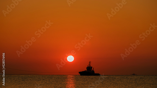 a ship leaving port at sunrise