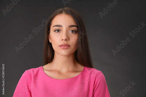 Portrait of beautiful young woman on dark grey background