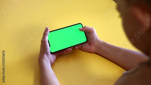 Child Using Phone With Green Mock-up. Surfing Internet Watching Content Videos Blogs Learning. boy Playing Video Games. chroma key for copy space. Slow motion.
