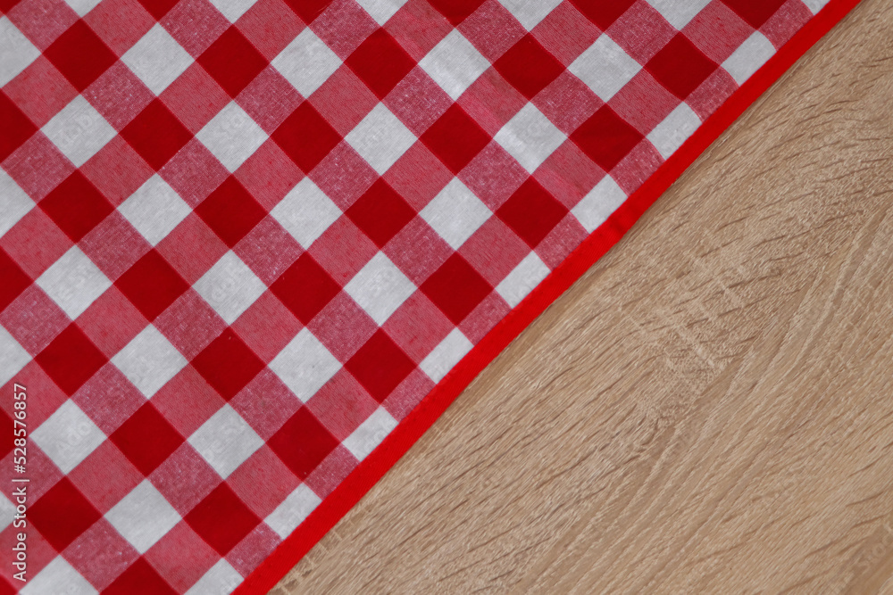 Checkered picnic cloth on wooden table, top view. Space for text Checkered picnic cloth on wooden table, top view. Space for text