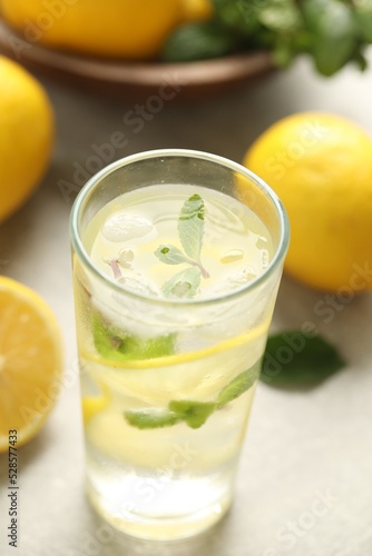 Cool freshly made lemonade in glass on light table, closeup