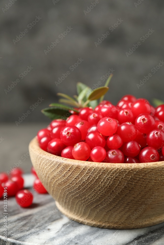 Tasty ripe cranberries on grey marble board, closeup Tasty ripe cranberries on grey marble board, closeup
