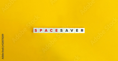 Space Saver Phrase on Block Letter Tiles on Yellow Background. Minimal Aesthetics.